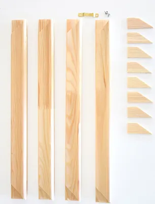 Wooden frame pieces and hardware laid out on a white background.