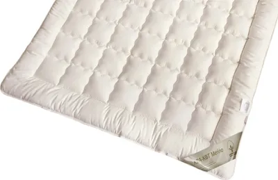 A quilted white mattress topper shown from a slight angle.