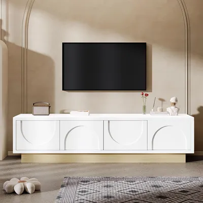A modern living room scene featuring a white TV stand with a gold base, a black television mounted above it, and decorative items on the stand.