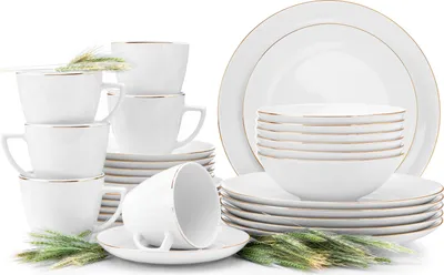 A set of white porcelain dinnerware and cups with gold trim, arranged on a white background with decorative greenery.