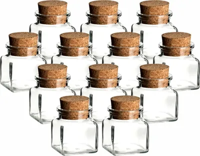 A group of small glass jars with cork stoppers arranged in rows.
