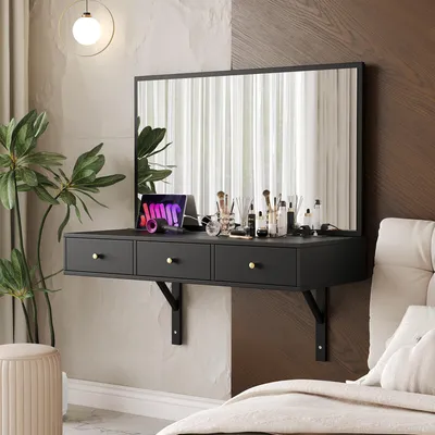 A modern black floating vanity desk with a large mirror, makeup accessories, and a tablet, set against a textured wall next to a bed.