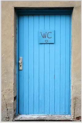 Produktbild von Wallario Wandbild Blaue Tür einer Toilette in einer verlassenen Fabrik in Magdeburg, Größe: 61 x 91,50 cm, Poster mit weißem Aluminiumrahmen