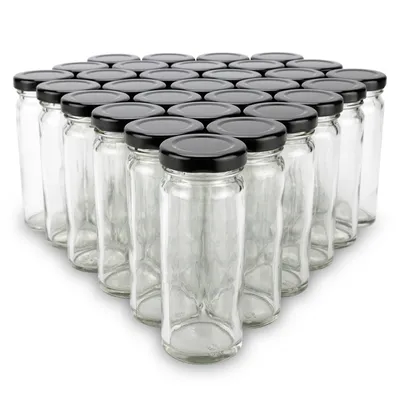A group of empty glass jars with black lids arranged in a pyramid formation on a white background.