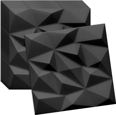 A stack of black 3D wall panels with a geometric, faceted design, with one panel placed in front of the stack.