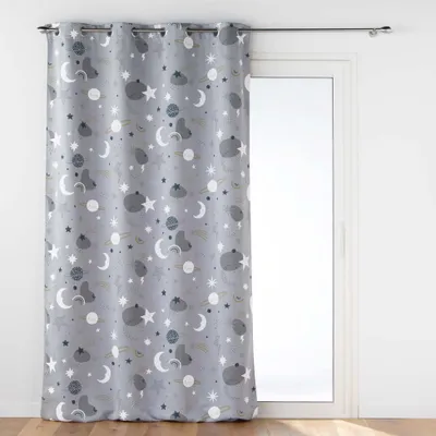 A curtain with a space-themed pattern hanging in front of a glass door.