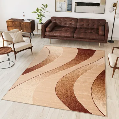 A living room scene with a sofa, armchair, rug, and side table.