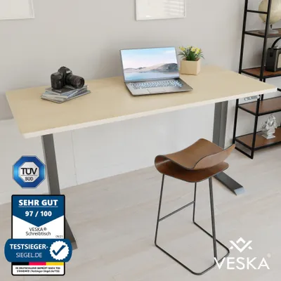 A modern office desk setup with a laptop, camera, and a stylish stool.