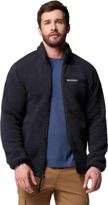 A man wearing a black fleece jacket and tan pants.