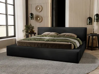 A bedroom scene with a black upholstered bed as the main focus.