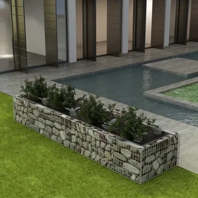 A gabion planter filled with plants is placed on a lawn next to a modern building with a swimming pool.