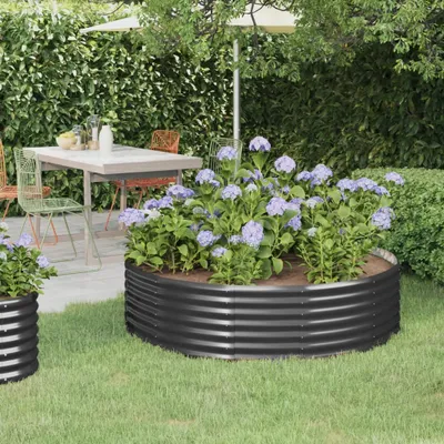 A garden scene with a raised garden bed filled with hydrangeas, a table and chairs, and a hedge in the background.
