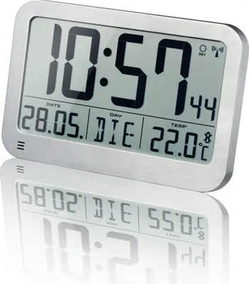 A digital weather station with a silver frame is shown against a white background, with its reflection visible below.