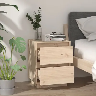 A wooden nightstand with two drawers next to a bed, with a plant and some books on top.