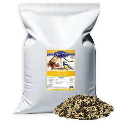 A large bag of birdseed with a pile of birdseed in front of it.