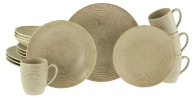 A collection of stoneware dinnerware, including plates and mugs, arranged on a white background.