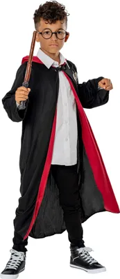 A young boy dressed as Harry Potter stands against a white background, holding a wand.