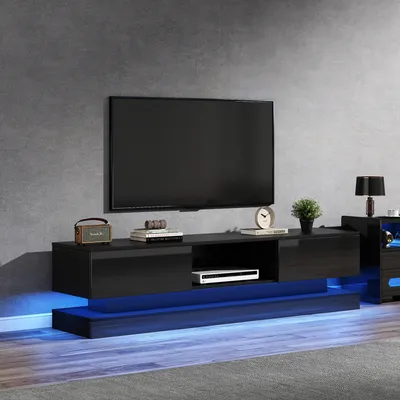 A modern living room setup featuring a wall-mounted TV and a sleek black TV stand with blue LED lighting.