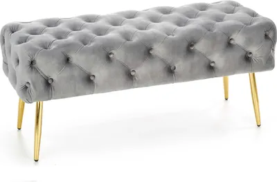 A tufted upholstered bench with gold legs on a white background.