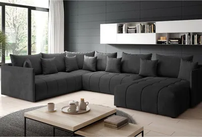 A modern living room with a large sectional sofa, coffee table, and shelves.