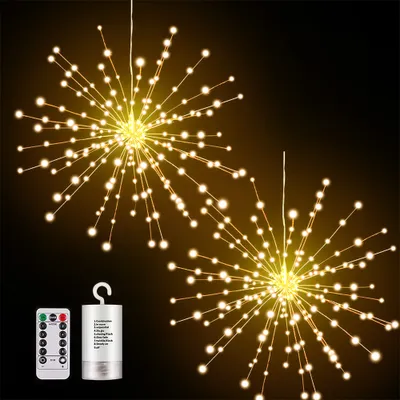 Two starburst-shaped string lights with warm white LEDs against a dark background, with a remote control and battery pack shown in the lower left corner.