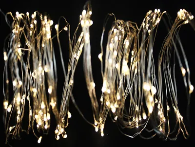A close-up of a string of small, warm white LED lights on a dark background.