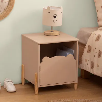 A child's bedroom with a bedside table and lamp.