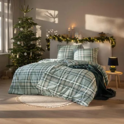 A bedroom decorated for Christmas with a Christmas tree and festive lights.