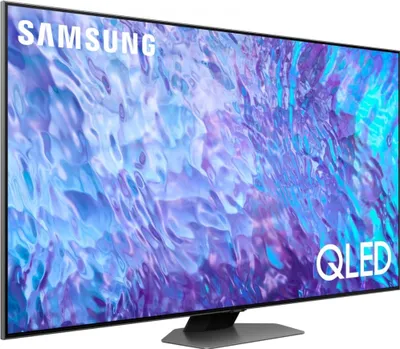 A Samsung QLED TV is shown from a side angle, displaying a colorful abstract image on its screen. The TV has a black bezel and a gray stand.