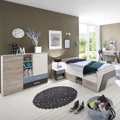 A child's bedroom with a bed, dresser, nightstand, rug, and desk visible.