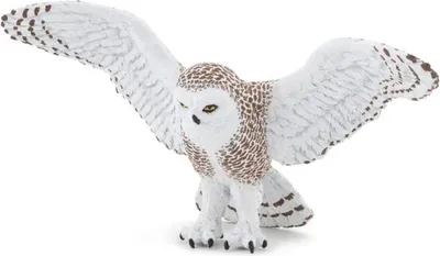 A toy snowy owl figurine in flight against a white background.