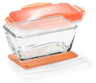 A glass loaf pan with an orange lid and an orange silicone mat.