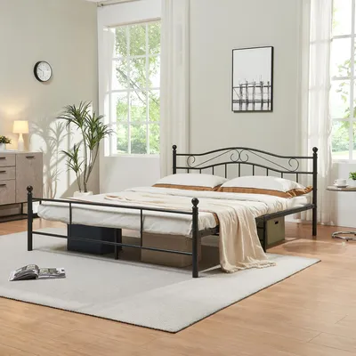 A bedroom scene with a metal bed frame, mattress, pillows, and a blanket.