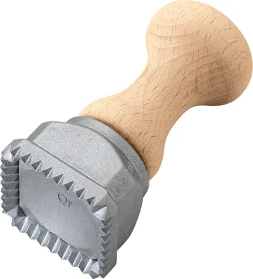 A ravioli stamp with a wooden handle.
