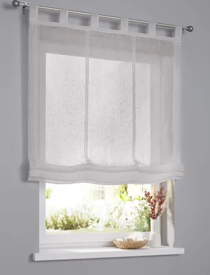 A white sheer Roman blind is shown hanging over a window, with a glimpse of greenery outside.