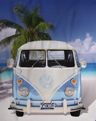 A vintage Volkswagen van on a beach with a palm tree.