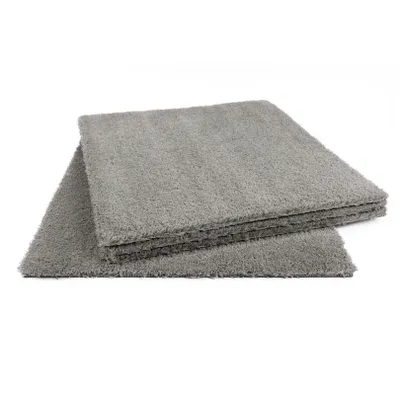 Several gray carpet tiles are stacked on top of each other against a white background.