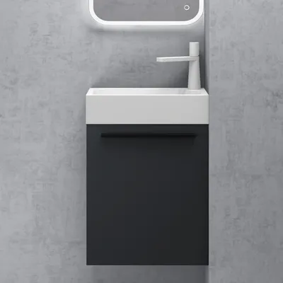 A modern bathroom vanity with a white sink and a dark gray cabinet against a textured gray wall.