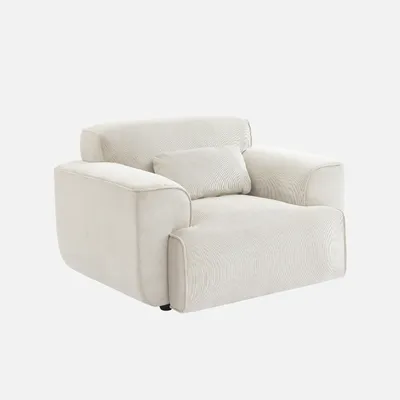 A cream-colored armchair with a corduroy texture and a small decorative pillow.