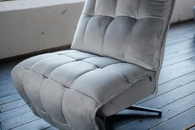 A close-up shot of a gray velvet armchair.