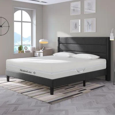 A bedroom scene with a mattress on a bed frame.