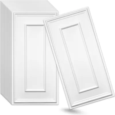 A stack of white decorative wall panels and one panel leaning against the stack.