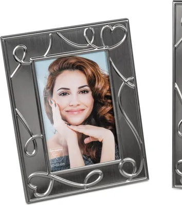A silver photo frame with a heart design, containing a picture of a woman.