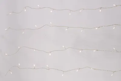 Four strands of white LED string lights are arranged horizontally against a light gray and white background.