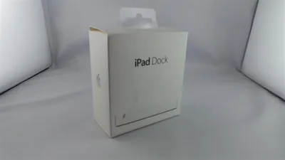 A white box for an Apple iPad Dock is shown against a white and light gray background.
