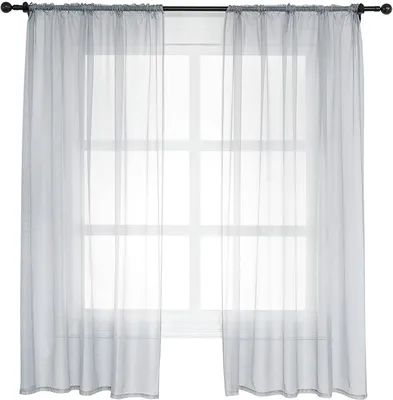 Two sheer gray curtains hanging on a window rod in front of a window with a grid pattern.