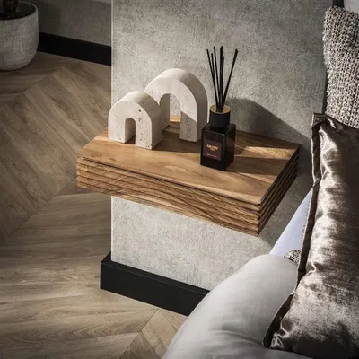 A wooden bedside table with decorative items and a diffuser.