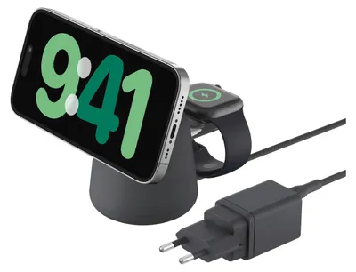 A wireless charging station with a smartphone and smartwatch placed on it, along with a power adapter and cable.