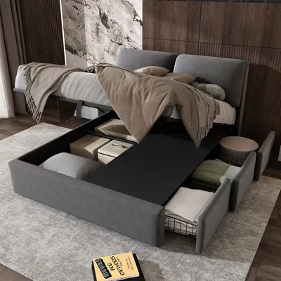A modern bedroom with a grey upholstered bed frame featuring hydraulic lift storage and drawers. The bed is made, with blankets and pillows.
