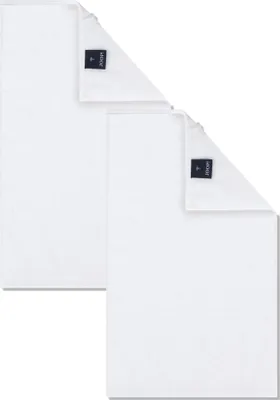 Two white guest towels are folded and stacked on a white background.